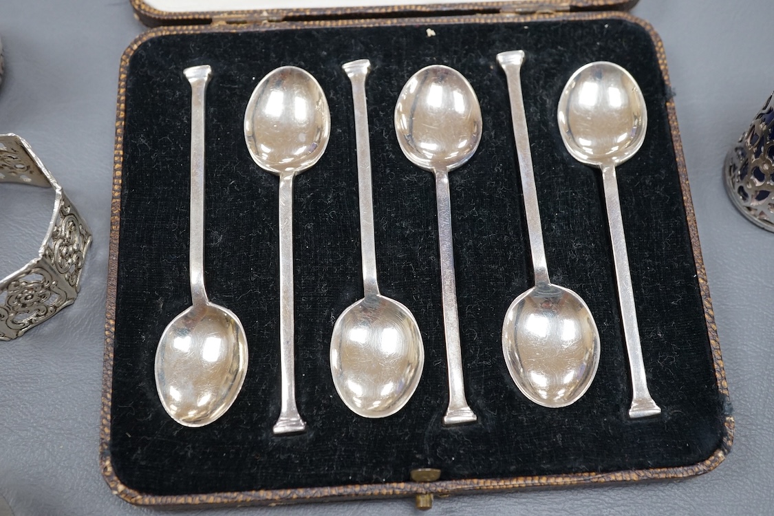 Four assorted silver napkin rings, two cased sets of six silver spoons, four silver condiments including a pair, a small group of sundry flatware, a silver wine label and a plated napkin ring.